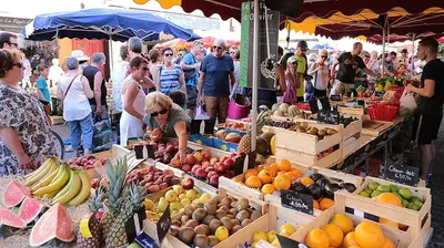 a crowd of people at a market with fruits and vegetables at Gîte de L'Olivier, classé, climatisé, jardin avec parking gratuit devant le logement et à 5 minutes du centre-ville à pied in LʼIsle-sur-la-Sorgue