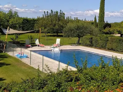 a pool with chairs and a hammock in a yard at Gîte la Cigale en pleine campagne in Carpentras