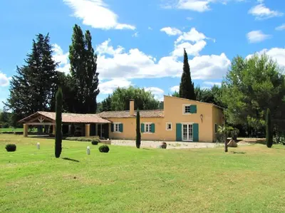 a house in a field with trees in the foreground at LUBERON - AIR CONDITIONING VILLA - 4 BEDROOMS - 4 BATHROOM in Lourmarin