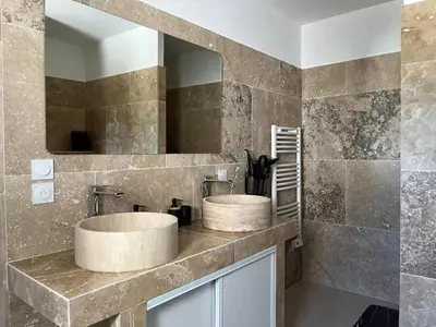 a bathroom with two sinks and a mirror at Villa charmante à Châteaurenard avec piscine privée in Châteaurenard
