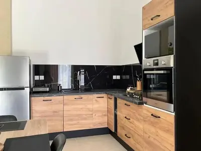 a kitchen with wooden cabinets and stainless steel appliances at Villa charmante à Châteaurenard avec piscine privée in Châteaurenard