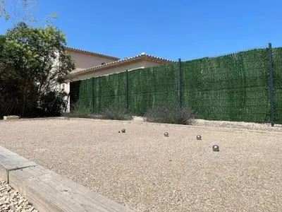 a backyard with a fence and some balls on the ground at Villa charmante à Châteaurenard avec piscine privée in Châteaurenard