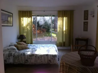 a bedroom with a bed and a large window at Les Merles : joli studio dans la campagne Aixoise. in Venelles