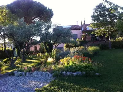 a garden with flowers and trees in a yard at Les Merles : joli studio dans la campagne Aixoise. in Venelles