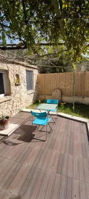 two chairs and a table on a wooden deck at Charmant studio indépendant dans la colline in Eyguières