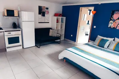 a blue room with a bed and a kitchen at Charmant studio indépendant dans la colline in Eyguières