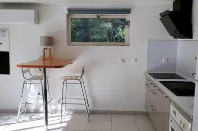 a small kitchen with a table and two stools at Charmant studio indépendant dans la colline in Eyguières