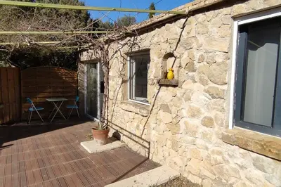 a stone building with a patio and a window at Charmant studio indépendant dans la colline in Eyguières