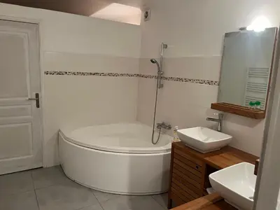 a white bathroom with a tub and a sink at Appartement privatif avec extérieur in Aubignan