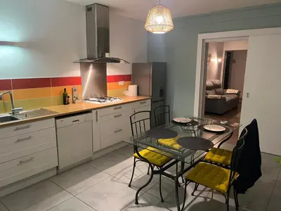 a kitchen with a table and chairs and a dining room at Appartement privatif avec extérieur in Aubignan