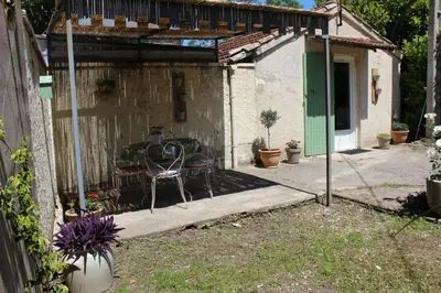 a patio with a table and a chair in a backyard at Lou Pitchoun Cabanoun à Eygalières 