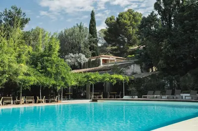 a swimming pool with a house in the background at Setclub Hôtel & Spa Aix-en-Provence in Aix-en-Provence