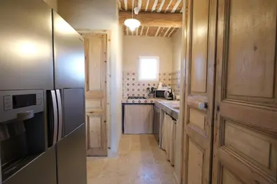 a kitchen with wooden cabinets and a refrigerator at Provencal farm with heated pool in Lamanon near Aix en Provence - 12 people in Lamanon