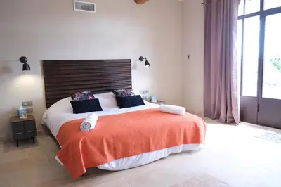 a bedroom with a large bed with a wooden headboard at Provencal farm with heated pool in Lamanon near Aix en Provence - 12 people in Lamanon