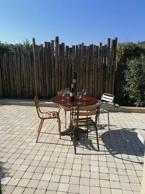 a table and chairs with wine glasses on a patio at Charmant T1 calme et reposant in Saint-Andiol