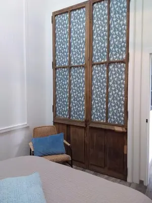 a bedroom with a window and a chair and a bed at Charmant T1 calme et reposant in Saint-Andiol
