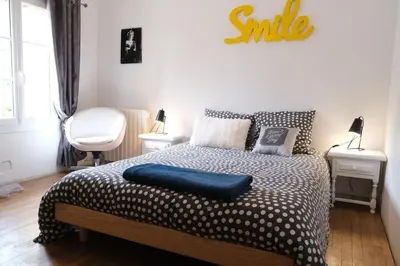 a bedroom with a bed with a smile sign on the wall at Typical farm with private pool close to the Ventoux 8 persons in Althen-des-Paluds
