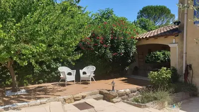 two white chairs sitting on a patio in a yard at Typical farm with private pool close to the Ventoux 8 persons in Althen-des-Paluds