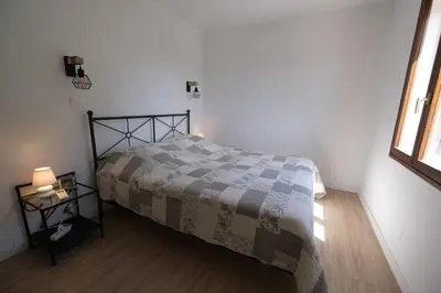 a bedroom with a bed with a blanket and a window at Air-conditioned house in the Luberon with heated swimming pool in Saint Saturnin les Apt - 8 people. in Saint-Saturnin-les-Apt