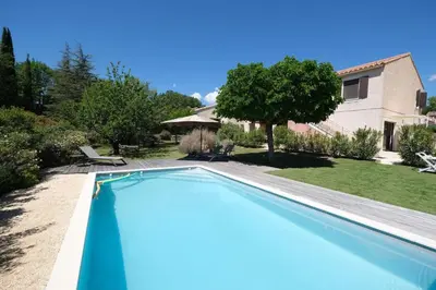 a swimming pool in front of a house at Air-conditioned house in the Luberon with heated swimming pool in Saint Saturnin les Apt - 8 people. in Saint-Saturnin-les-Apt