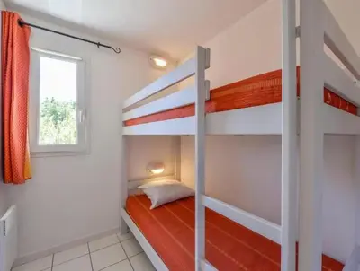 a bedroom with two bunk beds and a window at T2 Résidence Sun Hols les Rives du Lac piscine, jardin in Saint-Saturnin-lès-Avignon