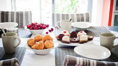 a table topped with plates of pastries and bowls of fruit at ELIA HOUSE in Goult