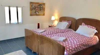 a bedroom with a large bed with a wooden headboard at ELIA HOUSE in Goult