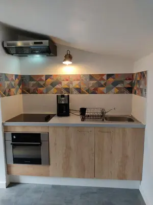 a kitchen with a sink and a stove top oven at Studio dans la forêt provençale in Jouques