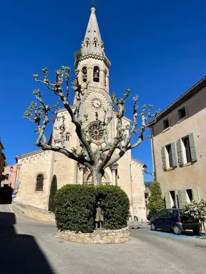 a church with a tower with a clock on it at La Farigoulette - Vieux village in Saint-Saturnin-les-Apt