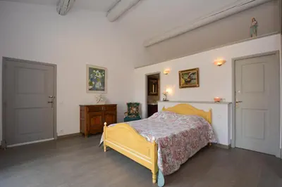 a bedroom with a yellow bed and two doors at St REMY AILLEURS in Noves