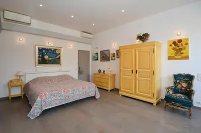 a bedroom with a bed and a cabinet and a chair at St REMY AILLEURS in Noves