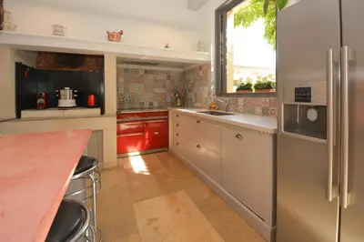 a kitchen with stainless steel appliances and red cabinets at St REMY AILLEURS in Noves