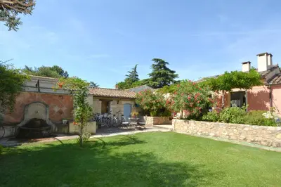 a house with a yard with a stone wall at St REMY AILLEURS in Noves