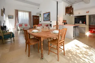 a kitchen and dining room with a wooden table and chairs at St REMY AILLEURS in Noves