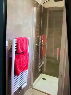 a shower with red towels on a rack in a bathroom at Studio Terrasse Privée Jardin Air conditionné in Aix-en-Provence