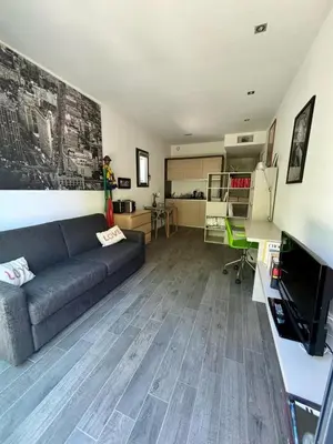 a living room with a couch and a desk at Studio Terrasse Privée Jardin Air conditionné in Aix-en-Provence
