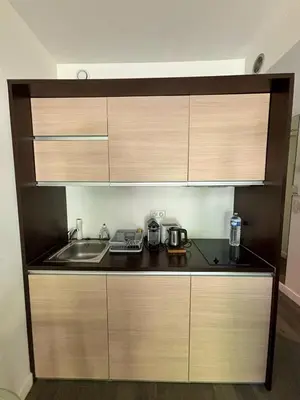 a kitchen with wooden cabinets and a sink at Studio Terrasse Privée Jardin Air conditionné in Aix-en-Provence