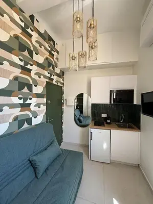 a bedroom with a blue bed and a kitchen at Studio Cosy au cœur d’Aix et & Cours Mirabeau in Aix-en-Provence