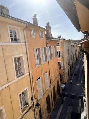 a bedroom with a bed with a white comforter at Mazarin Suite Centre ville historique proche cours Mirabeau in Aix-en-Provence