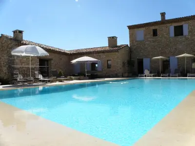 a large swimming pool in front of a building at Villa Helios in Rustrel