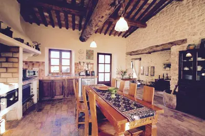 a large kitchen with a wooden table and chairs at Villa Helios in Rustrel