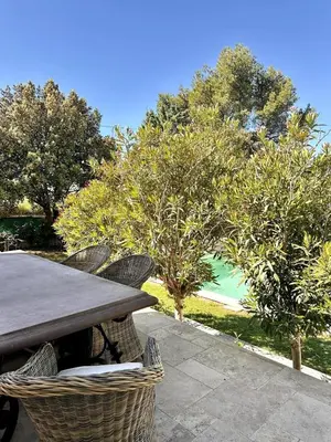 a wooden table and chairs on a patio at Les Lauriers Roses air-conditioned villa with garden and swimming pool in Saumane-de-Vaucluse