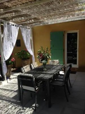 a wooden table and chairs on a patio at Villa provençale entre Aix en Provence et Luberon in Rognes
