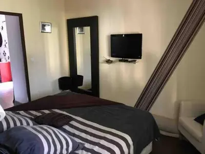 a bedroom with a bed and a tv on the wall at Villa provençale entre Aix en Provence et Luberon in Rognes