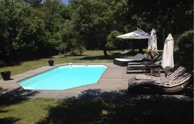 a swimming pool with two chairs and an umbrella at Villa provençale entre Aix en Provence et Luberon in Rognes
