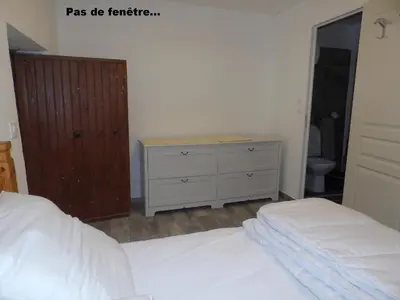 a bedroom with a white bed and a dresser at Studio chez Steph in Eyguières