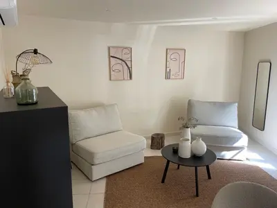 a living room with a couch and a chair and a table at UN DOUX MOMENT in Pernes-les-Fontaines
