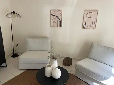 a living room with a couch and two vases on a table at UN DOUX MOMENT in Pernes-les-Fontaines