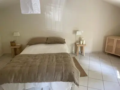 a bedroom with a bed and two tables with lamps at UN DOUX MOMENT in Pernes-les-Fontaines