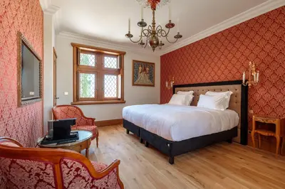 a bedroom with a bed and a desk with a laptop at Domaine Jourdan in Le Puy-Sainte-Réparade